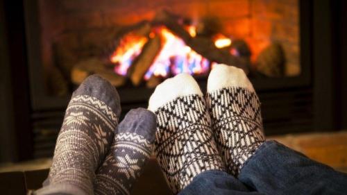 a person in socks sitting in front of a fireplace at Pla del Castell II in Albarca