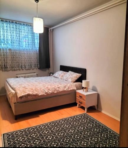 a bedroom with a bed and a nightstand and a window at Şişli Özcan 1 in Istanbul