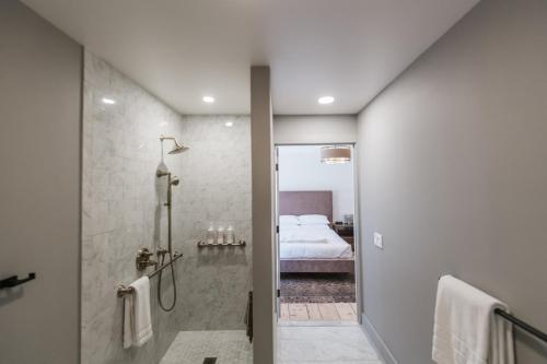 ein Bad mit einer Dusche und ein Schlafzimmer mit einem Bett in der Unterkunft Old Dutch Inn in Kinderhook