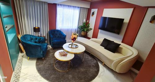a living room with a couch and chairs and a television at Saladin Boutique Hotel in Jerusalem