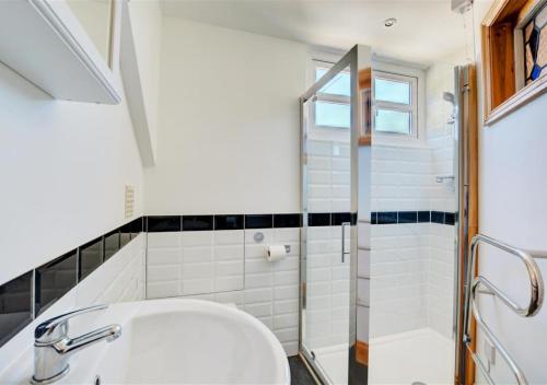 ein Badezimmer mit Waschbecken und Dusche in der Unterkunft Rose Cottage in Stiffkey