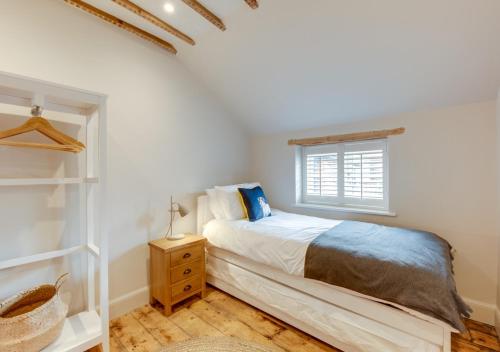 a bedroom with a bed and a window at Peacock Cottage in Holt