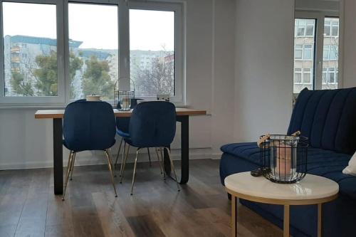 salon ze stołem, 2 krzesłami i kanapą w obiekcie Apartment in the heart of Bialystok w mieście Białystok