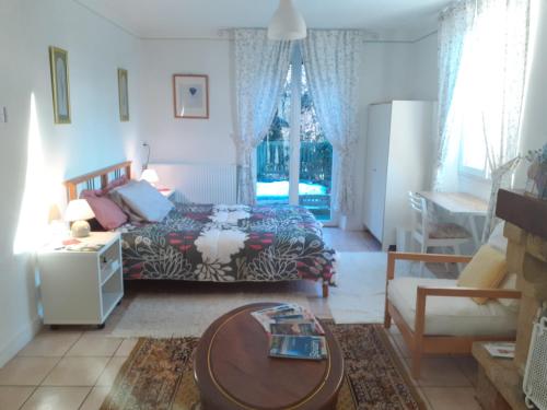 a living room with a bed and a table at chez Black and White in Les Martys