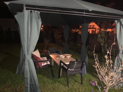 a table and chairs under a tent in a yard at K&B Residence in Jarosław