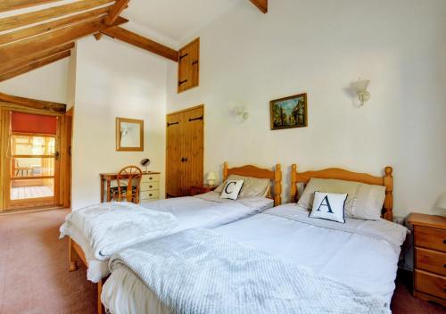 two beds in a bedroom with white sheets at Rectory Barn in Ashwellthorpe