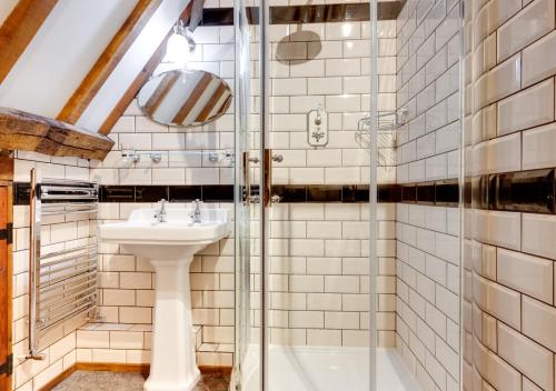 a bathroom with a sink and a shower at Reclaim Cottage in Colkirk