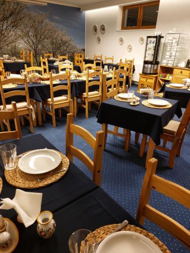 a dining room with black tables and wooden chairs at Penzion Sonáta in Luhačovice