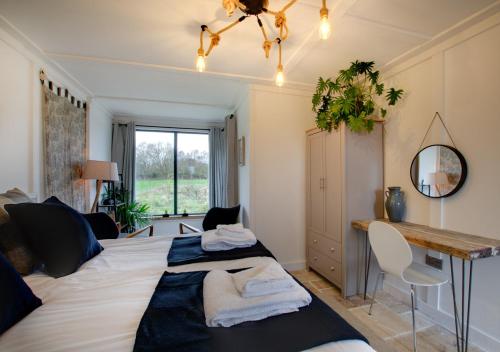 a bedroom with a large bed and a desk at Roe Deer Barn in Briston