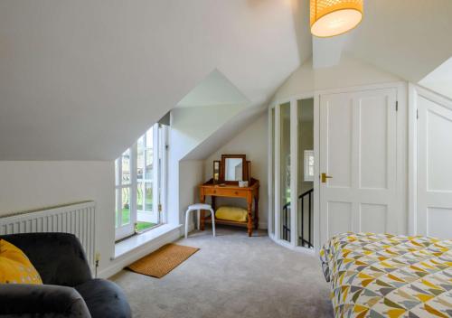 a bedroom with a bed and a desk with a mirror at Rose Cottage - West Runton in West Runton