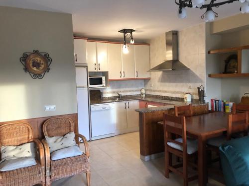 cocina con mesa y sillas y comedor en Espectacular Los Rosales de Gredos, en Hoyos del Espino