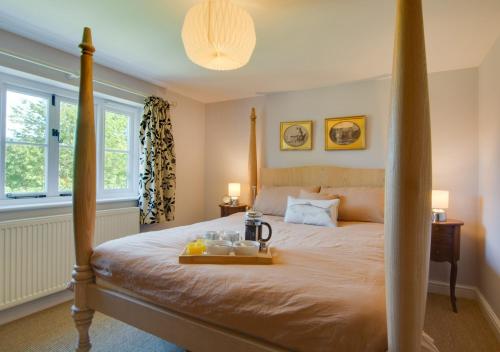 a bedroom with a bed with a tray of food on it at South Cottage in Antingham