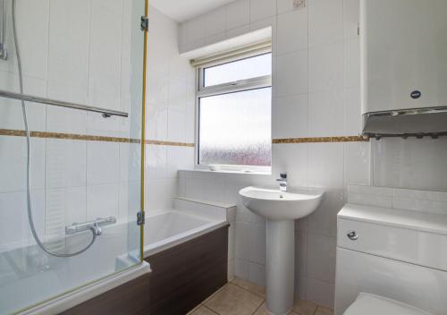 a bathroom with a sink and a toilet and a shower at Seaspray in Sheringham