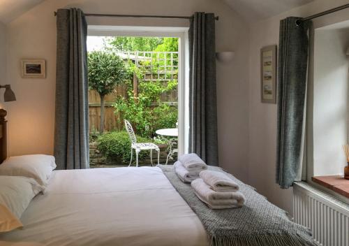 a bedroom with a bed with towels on it at Poppy Cottage in Stiffkey