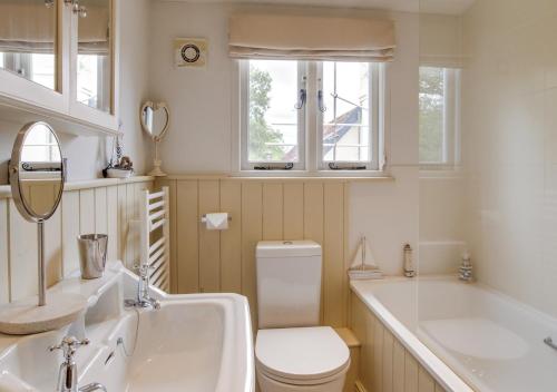 a bathroom with a toilet and a tub and a sink at Rose Lodge in Yaxham