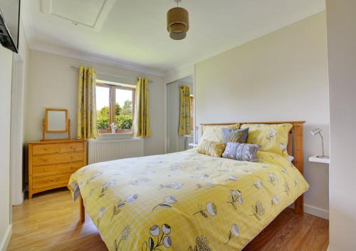 1 dormitorio con 1 cama con colcha amarilla en Skipjack Field View en Ingworth