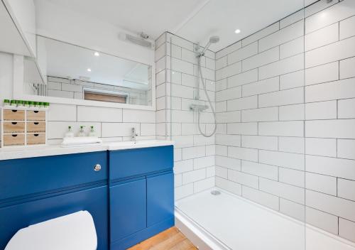 a bathroom with a blue sink and a tub at Silvergate Cottage in West Runton