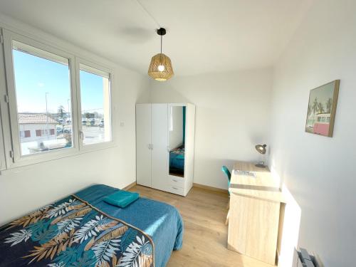 een slaapkamer met een bed, een bureau en 2 ramen bij Appartement 3 Chambres - Climatisation - Parking in Portet-sur-Garonne