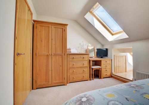 a bedroom with a bed and a desk and a skylight at Skipjack in Ingworth