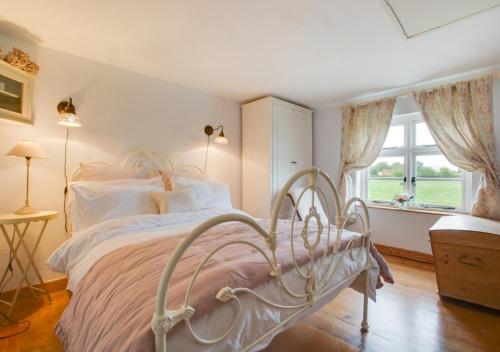 a bedroom with a white bed and a window at Sky Cottage in Worstead