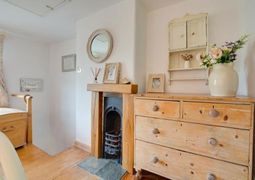 a room with a dresser with a vase on it at Sky Cottage in Worstead