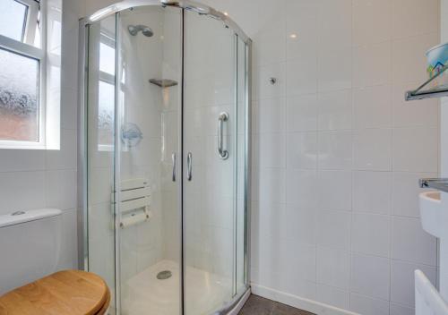 a glass shower in a bathroom with a toilet at Sandy Bottom in Hunstanton