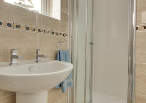 a bathroom with a white sink and a shower at Sandringham in Walcott