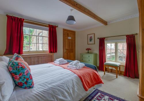 a bedroom with a large bed with red curtains at St Lawrence House 