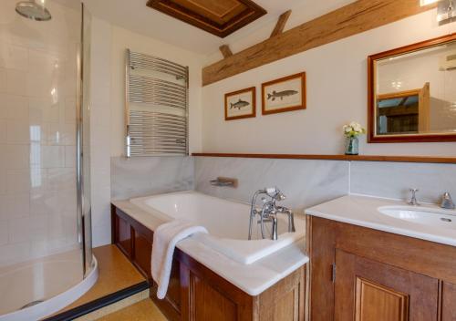 uma casa de banho com uma banheira, um lavatório e um chuveiro em St Lawrence House 