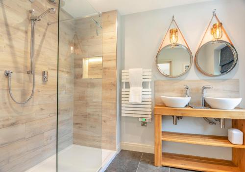 a bathroom with two sinks and a shower at South Way in West Runton