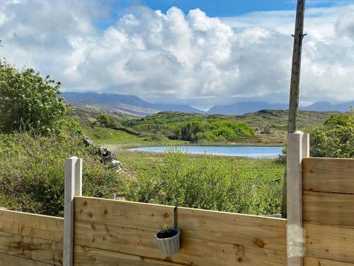 a wooden fence with a view of a lake at Cabin 438 - Clifden in Clifden