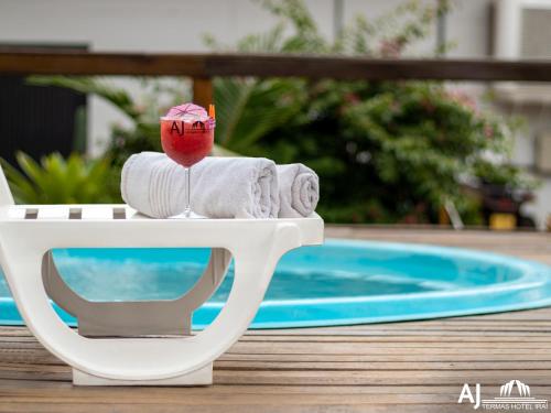 a table with towels and a fruit on it next to a pool at AJ TERMAS HOTEL IRAÍ in Iraí