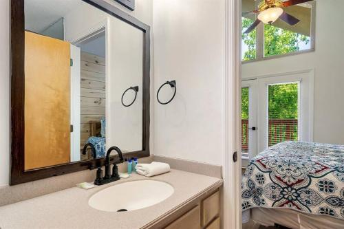 a bathroom with a sink and a mirror and a bed at Cozy Getaway in Pigeon Forge