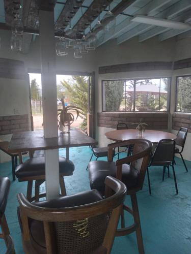 a room with two tables and chairs and windows at Casa Campo Rancho Villarino in Ensenada