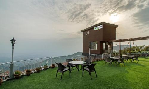 a restaurant with tables and chairs on a balcony at Treebo Raj Mall Road in Mussoorie
