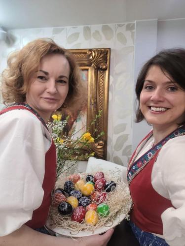 two women standing next to each other holding a bowl of fruit at Penzion Sinfonietta in Luhačovice