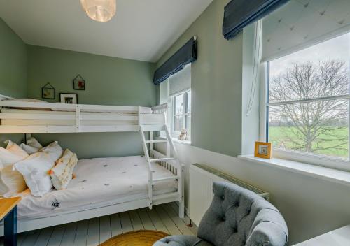 a bedroom with two bunk beds and a window at Tamerisk in Tunstead