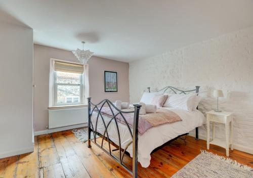 een slaapkamer met een bed, een tafel en een raam bij Tern Cottage in Wells next the Sea