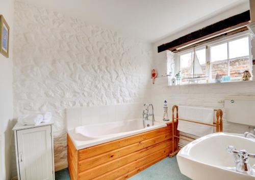 een witte badkamer met een bad en een wastafel bij Tern Cottage in Wells next the Sea