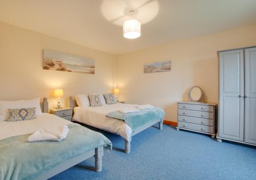 a bedroom with two beds and a dresser at Sunset Lodge in Wighton