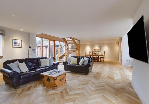 a living room with two couches and a tv at The Granary in Banningham