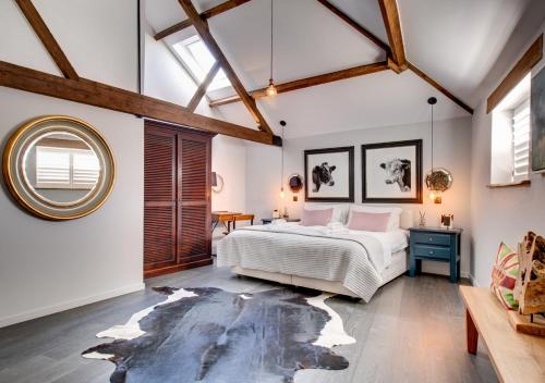 a bedroom with a large bed and a round mirror at The Cattle Shed in Wighton