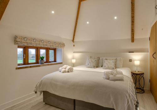 a bedroom with a large white bed with two pillows at The Granary in Banningham