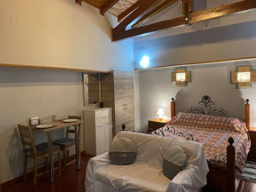 a bedroom with a bed and a table and a desk at Wooden interior in village krini. in Corfu Town