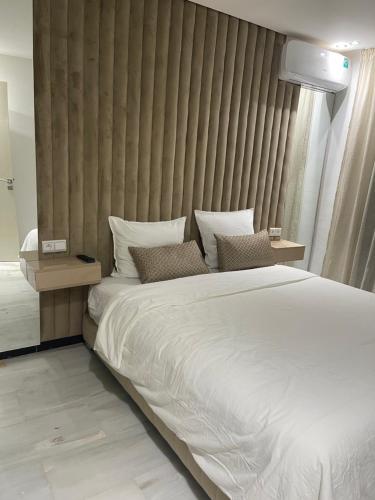 Un dormitorio con una gran cama blanca y una pared en Super appartement centre ville en Marrakech