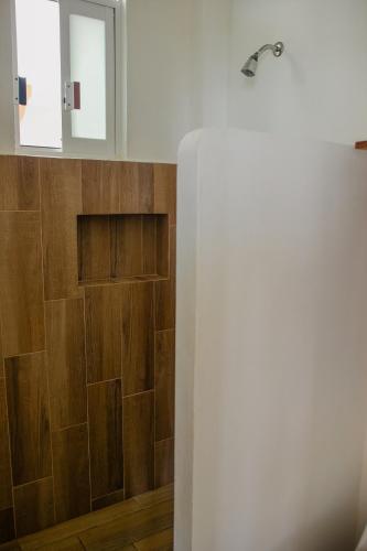 a bathroom with wood paneling and a mirror at Grand Casalet in Puerto Escondido
