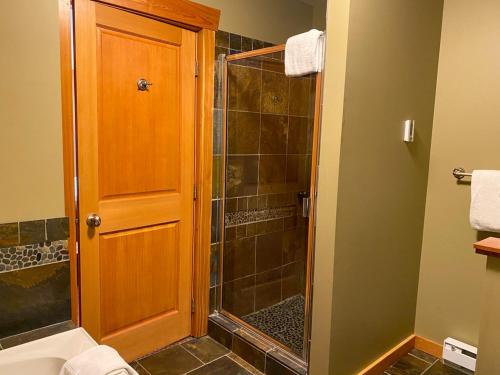 a bathroom with a shower with a glass door at Pinnacle Ridge Condos by Fernie Central Reservations in Fernie