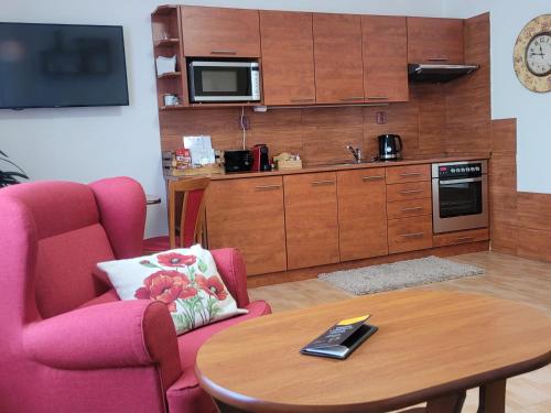 a living room with a table and a kitchen at Penzion Sinfonietta in Luhačovice