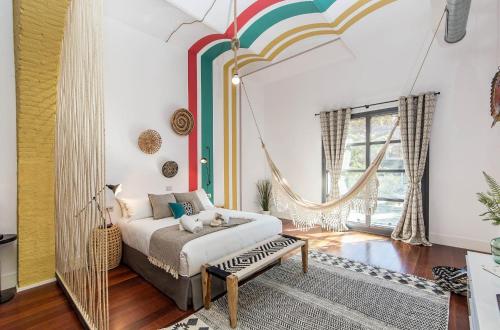 ein Schlafzimmer mit einem Schaukelbett und einer Regenbogenwand in der Unterkunft Sweet Inn - Loft Villa Olimpica Beach in Barcelona
