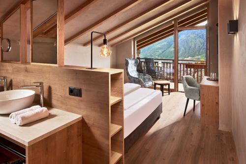 baño con cama y vistas a la montaña en Hotel-Garni Ehrenfels, en Scena